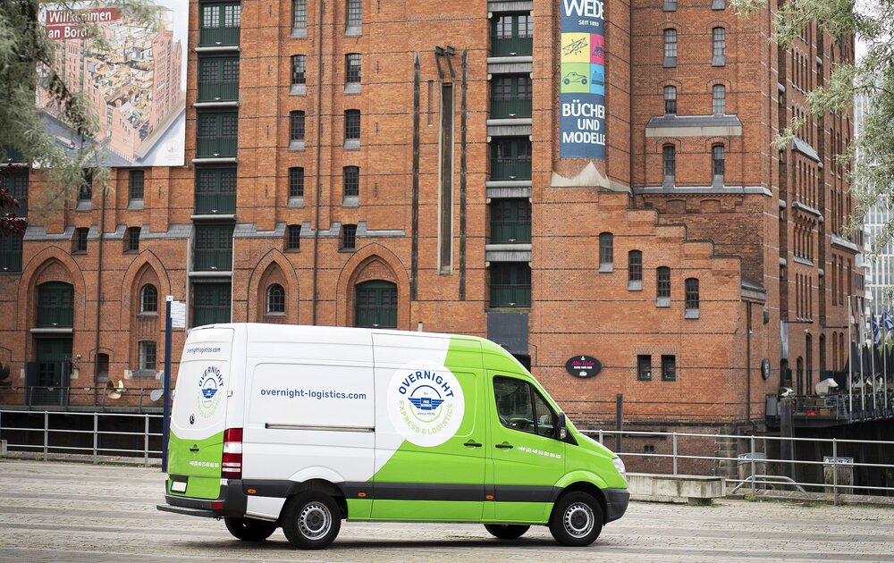 Ein grüner Lieferwagen steht vor einem historischen Backsteingebäude mit der Aufschrift „Maritimes Museum“. Der Himmel ist bewölkt.