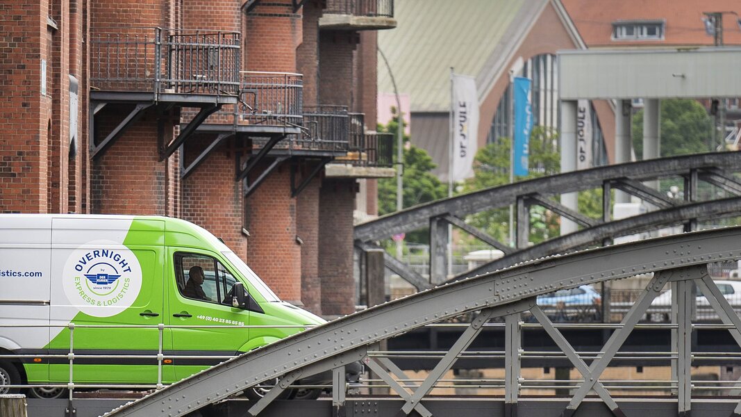 Ein Transporter von OverNight Express & Logistics als schneller Kurierdienst in der Stadt.