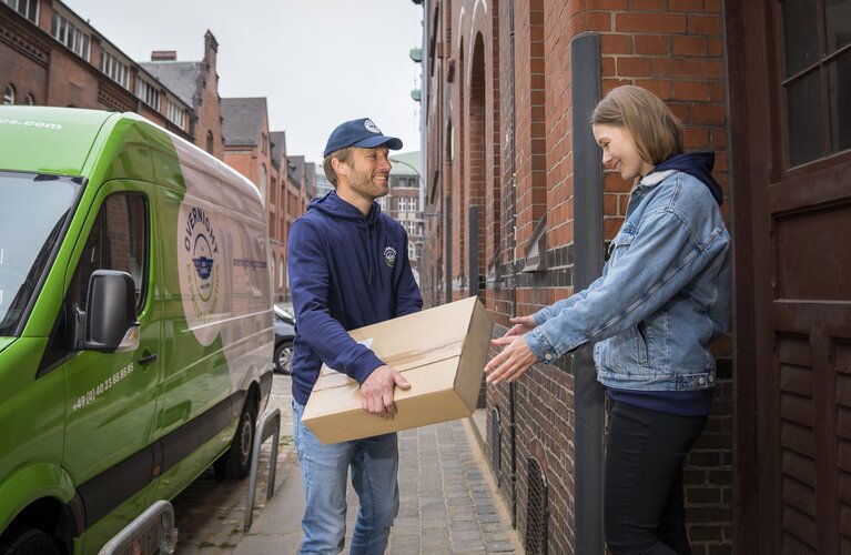 Ein Zusteller übergibt ein Paket an einen Empfänger, der bar bezahlt, um den Prozess der Nachnahme zu illustrieren.