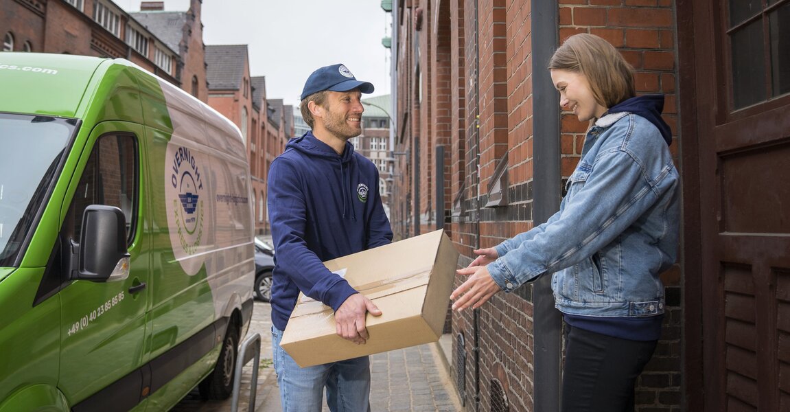 Ein Zusteller übergibt ein Paket an einen Empfänger, der bar bezahlt, um den Prozess der Nachnahme zu illustrieren.